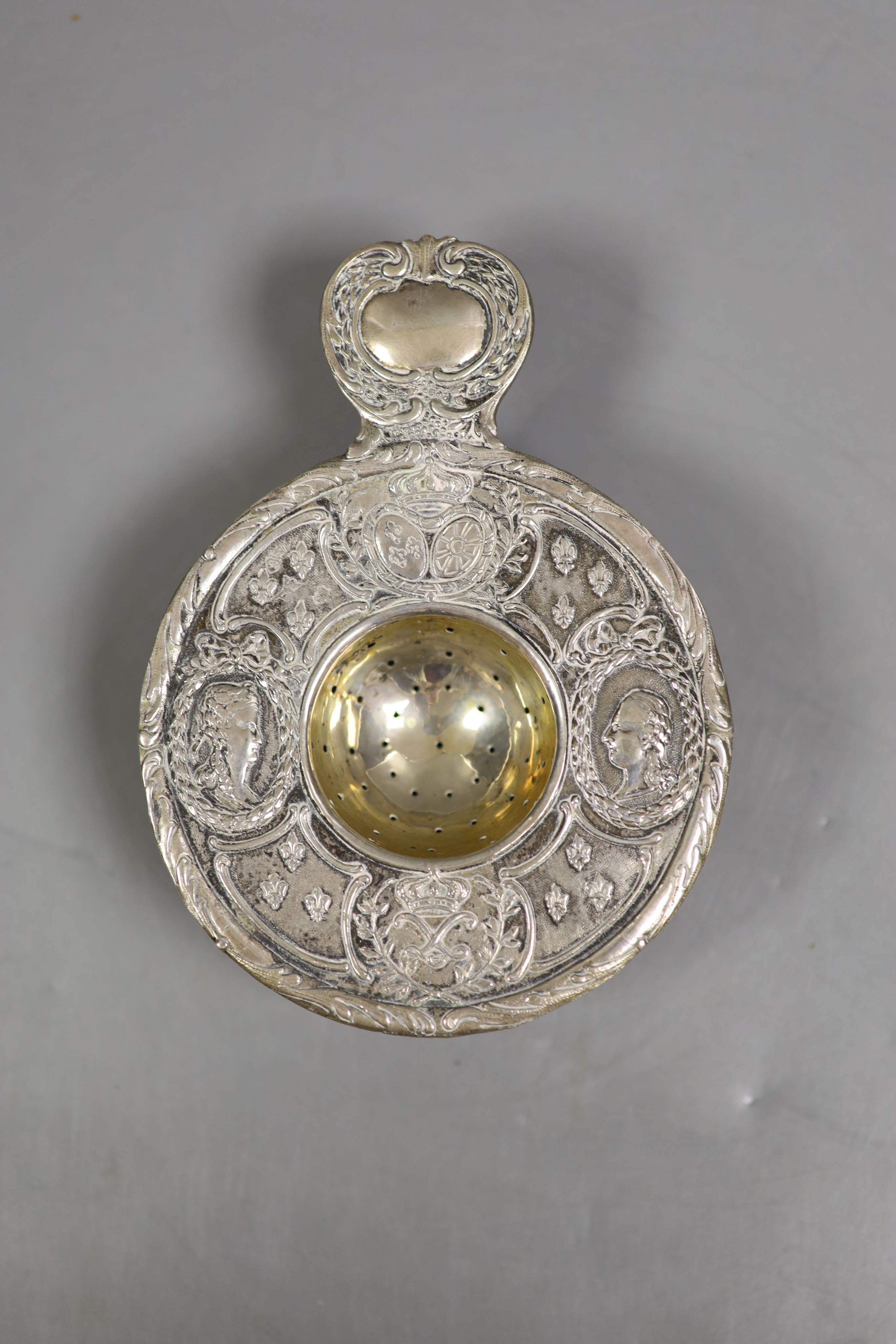 A 19th century continental white metal strainer, 13.6cm and the top section of a George III wine funnel, London, 1797, diameter 87mm, gross 121 grams.